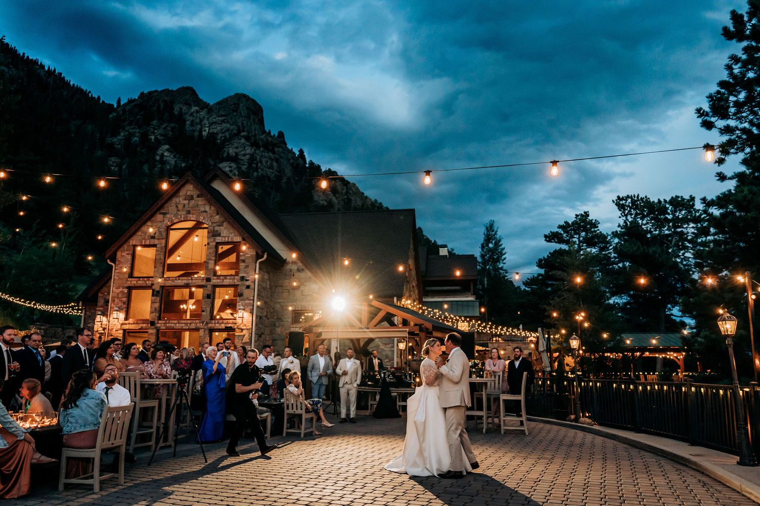 Wedding celebration at a rustic mountain lodge with string lights and evening ambiance.