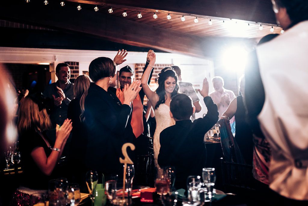Lively party scene at night with crowd dancing under string lights.