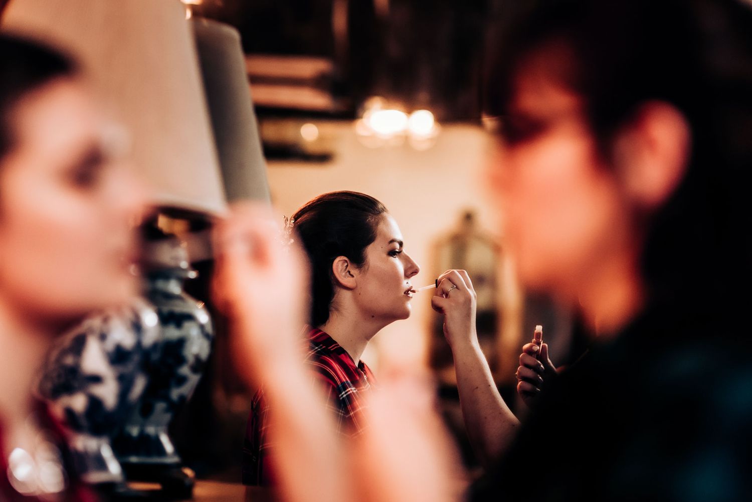 Makeup application scene with soft focus and candlelight ambiance.