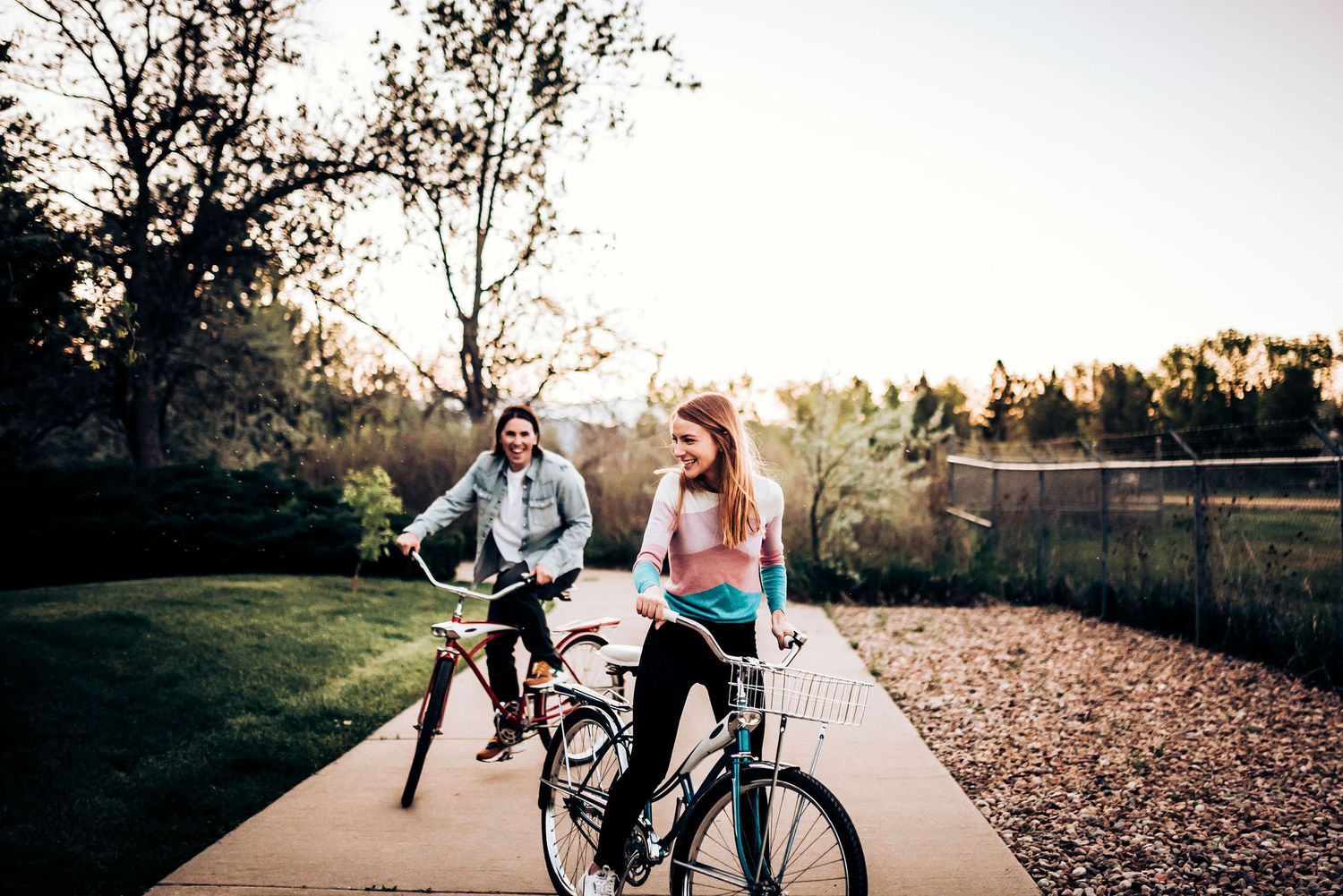 Two cyclists enjoy a leisurely ride along a scenic path at sunset.