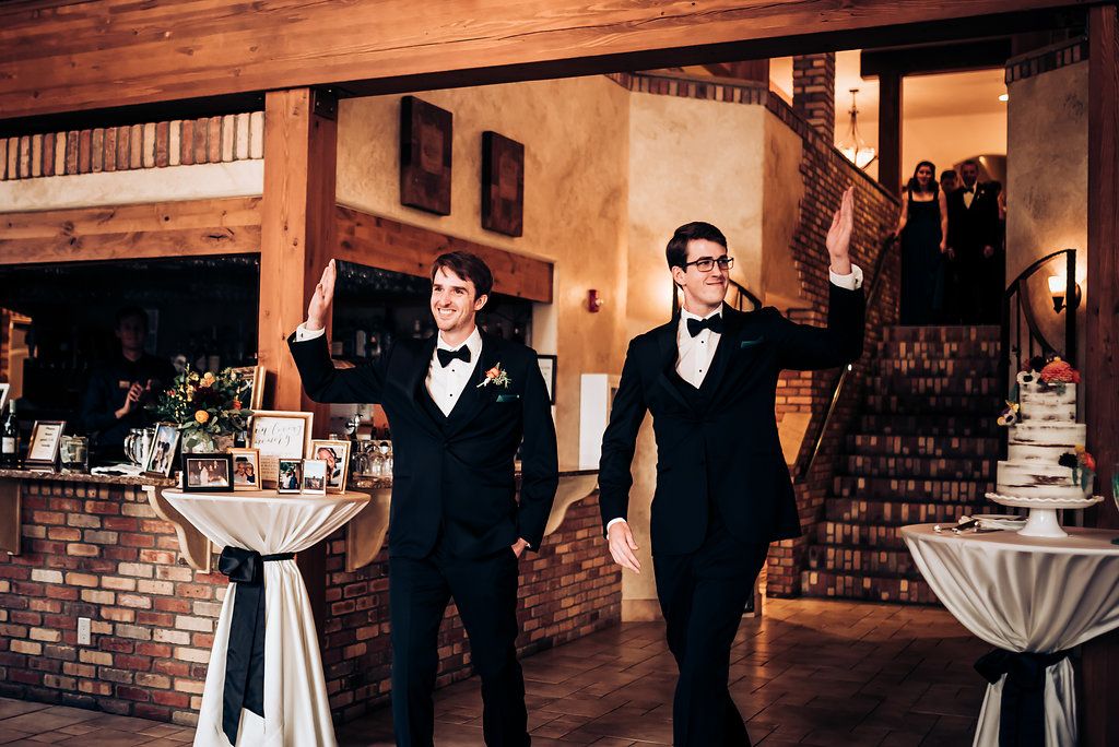 Reception venue interior featuring rustic brick walls and elegant white cocktail tables.
