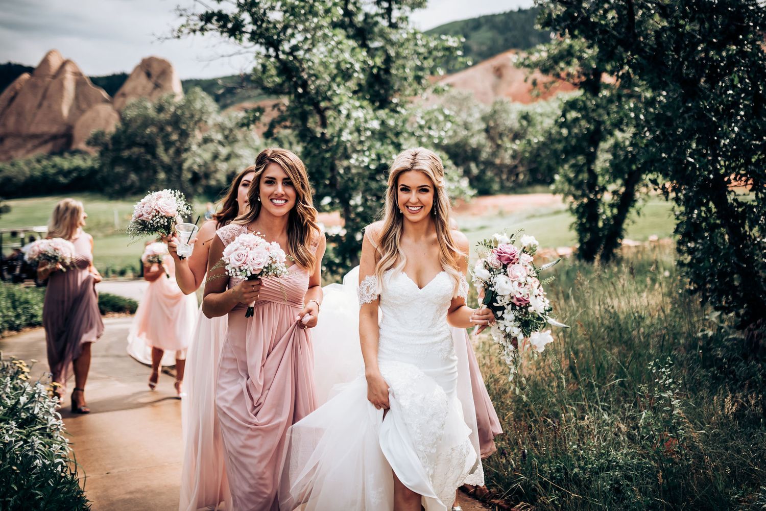 Wedding party walking along path with dramatic red rocks in background.