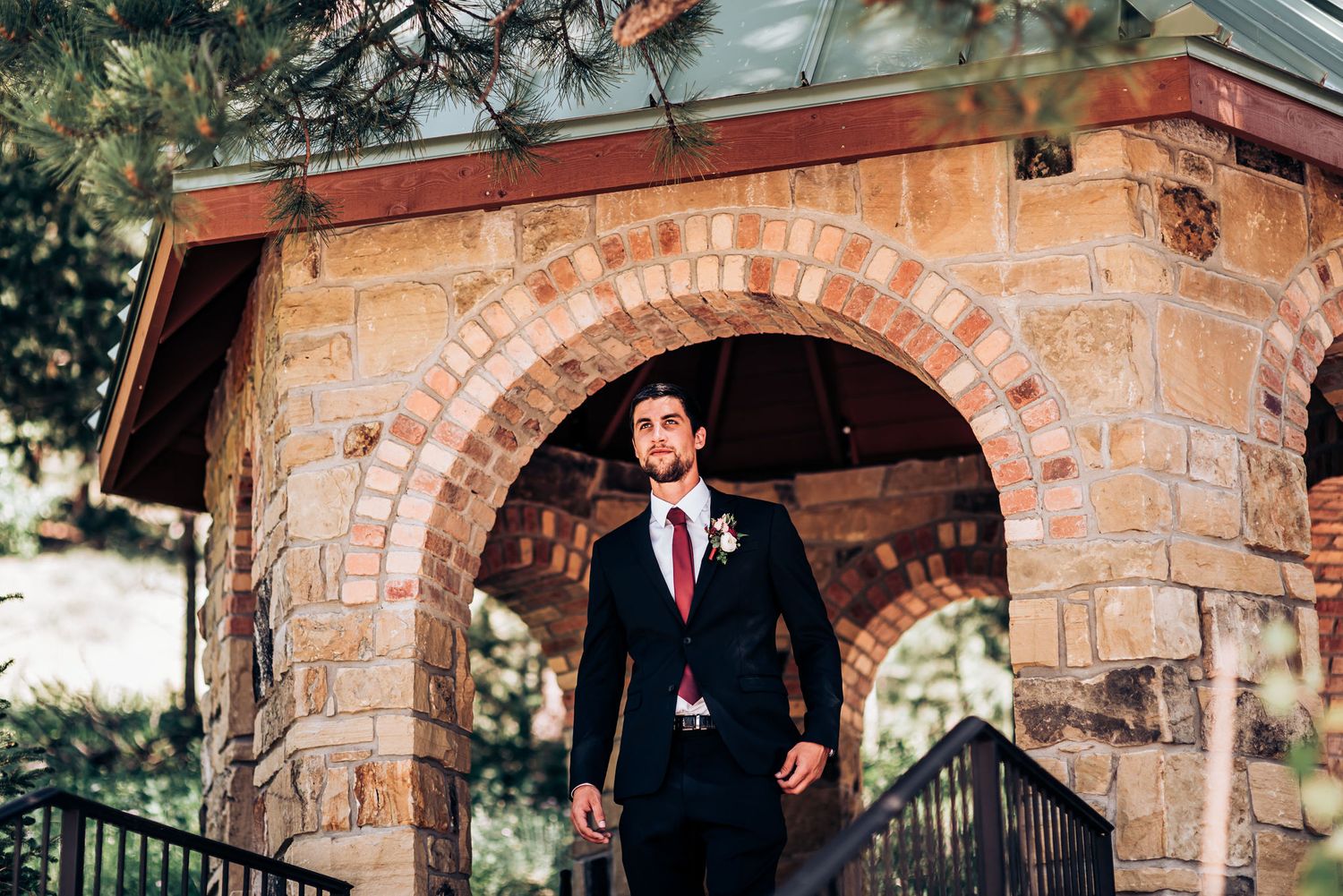 Elegant stone archway entrance with a figure in formal attire standing beneath.