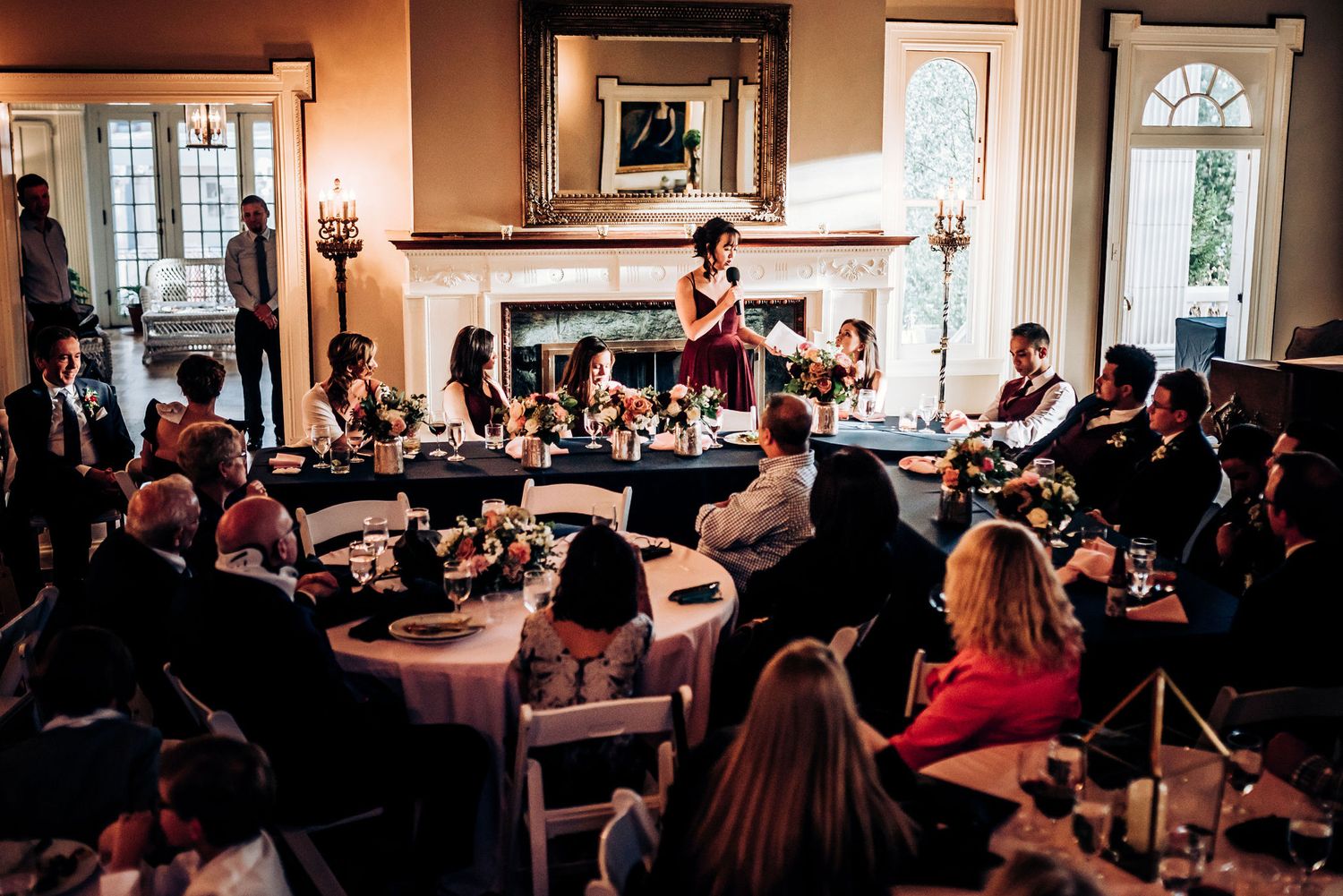 Guests gathered in an elegant room with fireplace for a reception celebration.