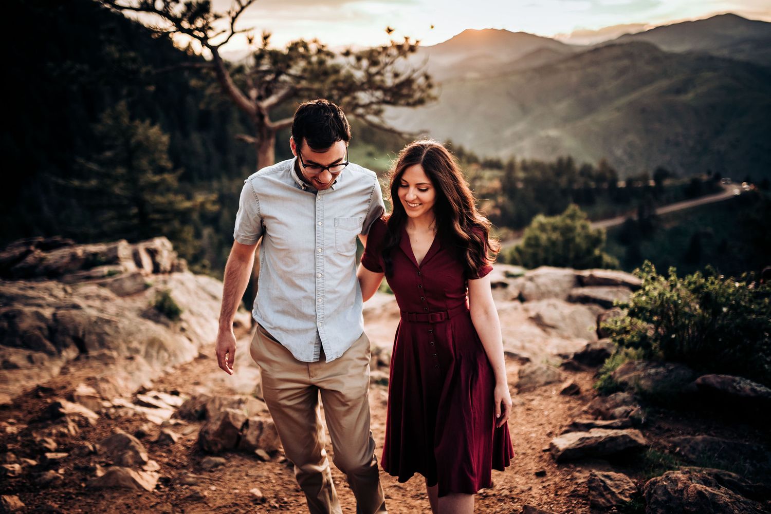 Couple hiking along scenic mountain trail during sunset.