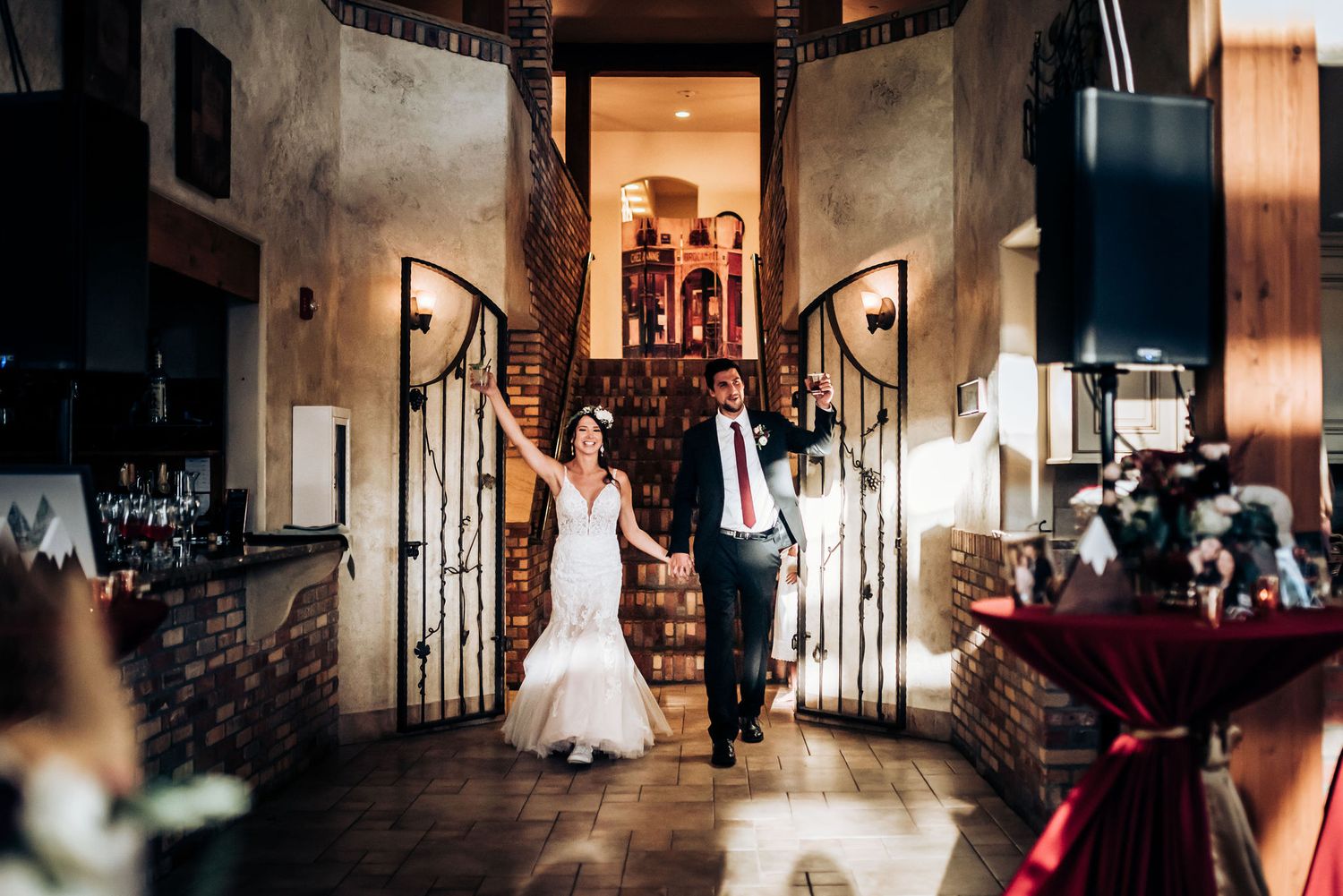 Grand entrance through decorative doorway in rustic wedding venue with spiral staircases.