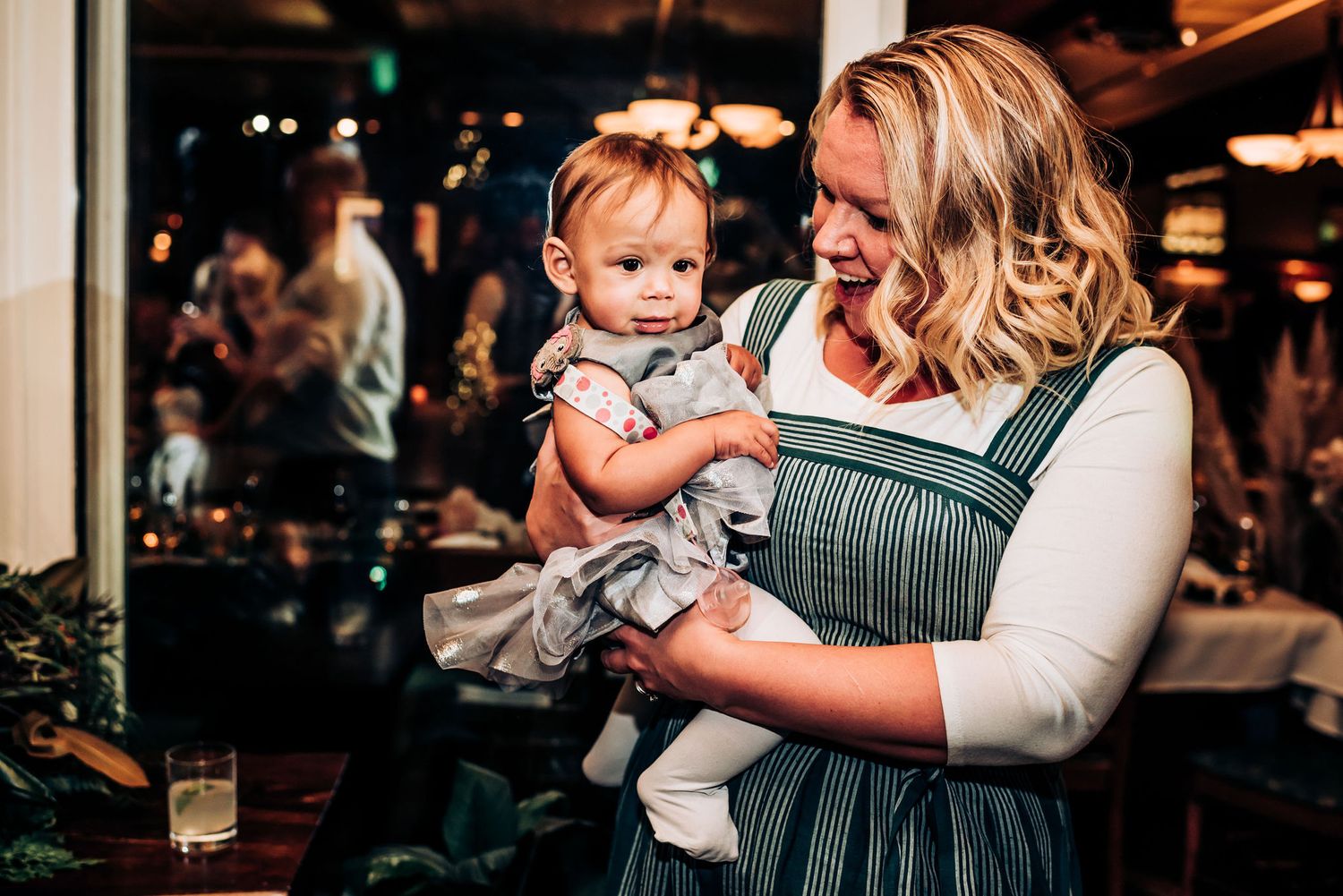 A candid moment captured at a social gathering with warm lighting and festive atmosphere.