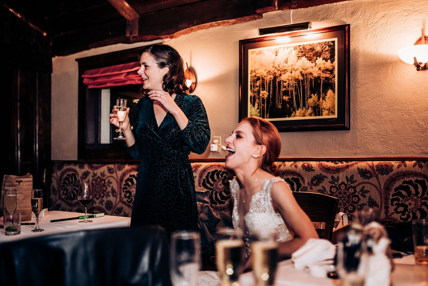 Two people sharing drinks and conversation at an elegantly decorated restaurant.