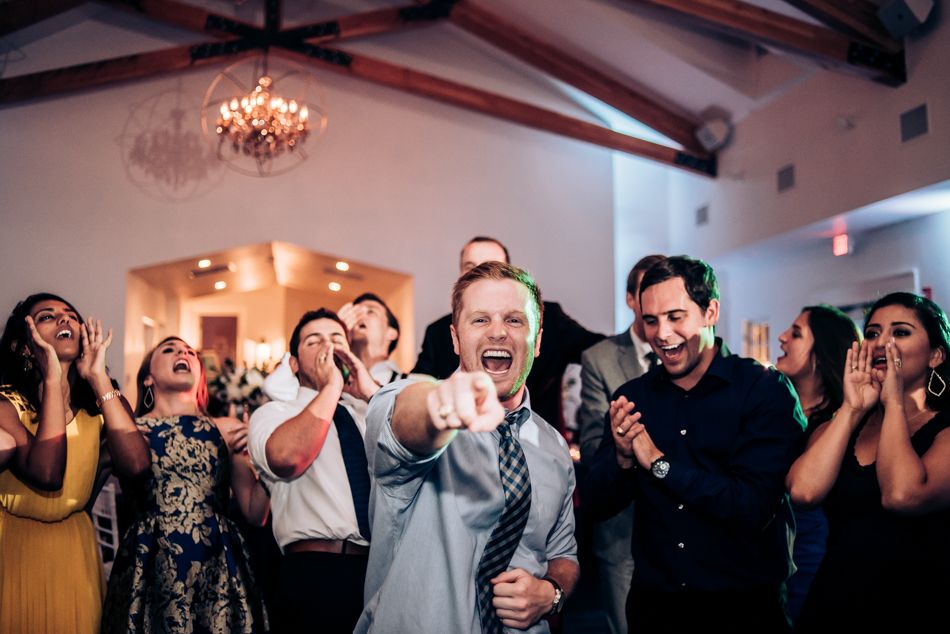 Wedding guests react with excitement during reception celebration.