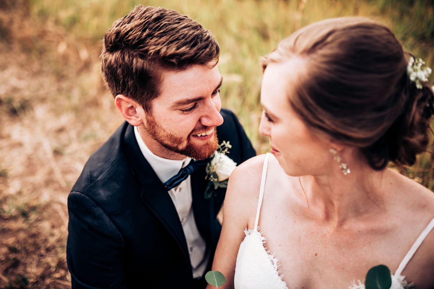 An intimate wedding moment captured in golden light with mountains in the background.