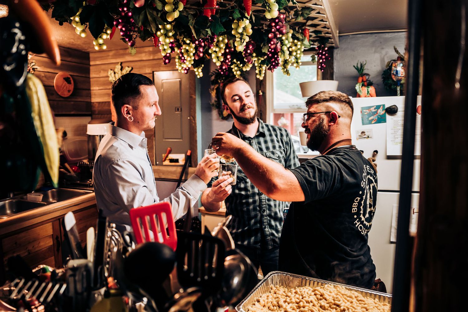 Friends toasting and celebrating under festive holiday decorations at indoor gathering.