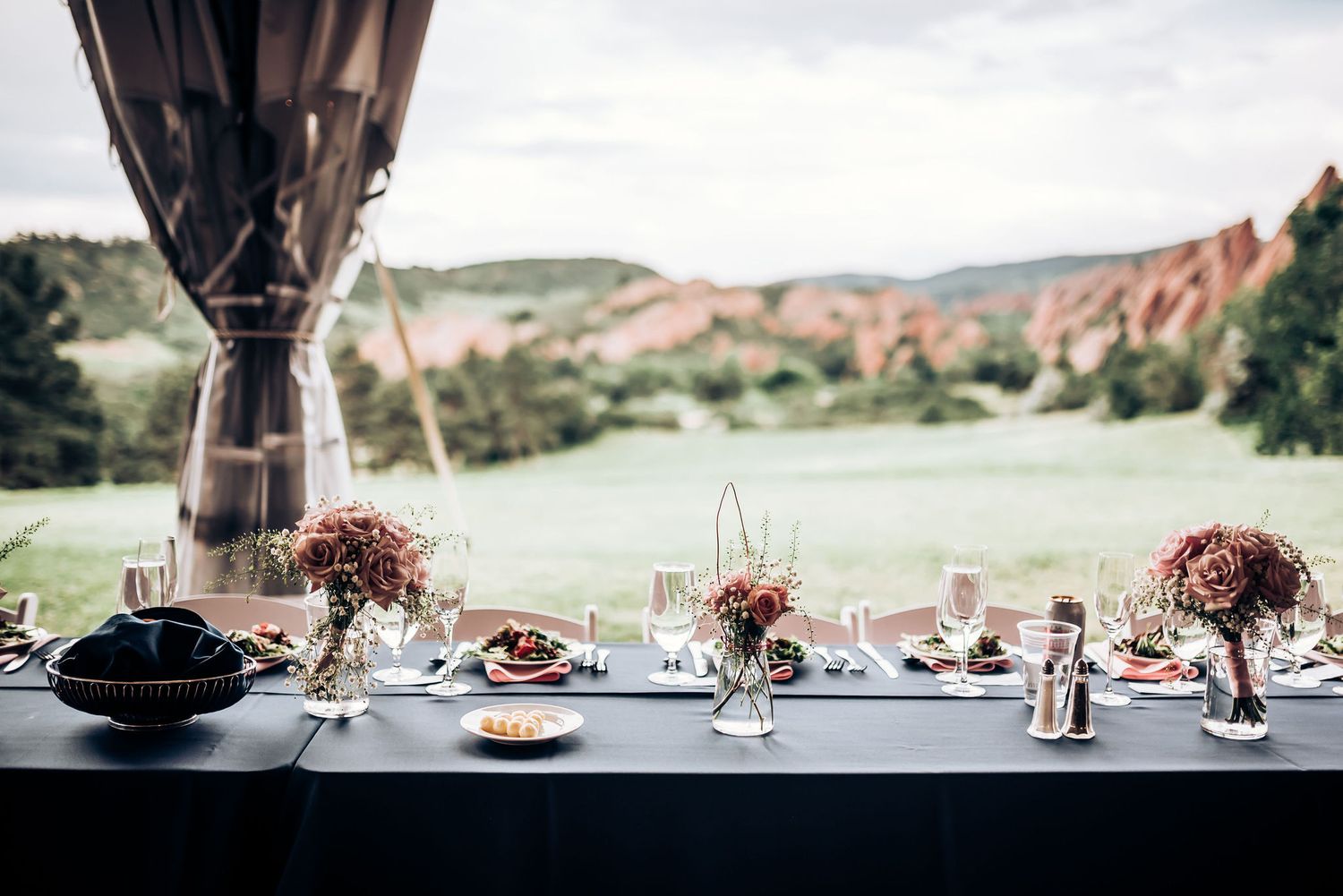 Elegant outdoor wedding reception table setup against dramatic Red Rocks landscape backdrop.