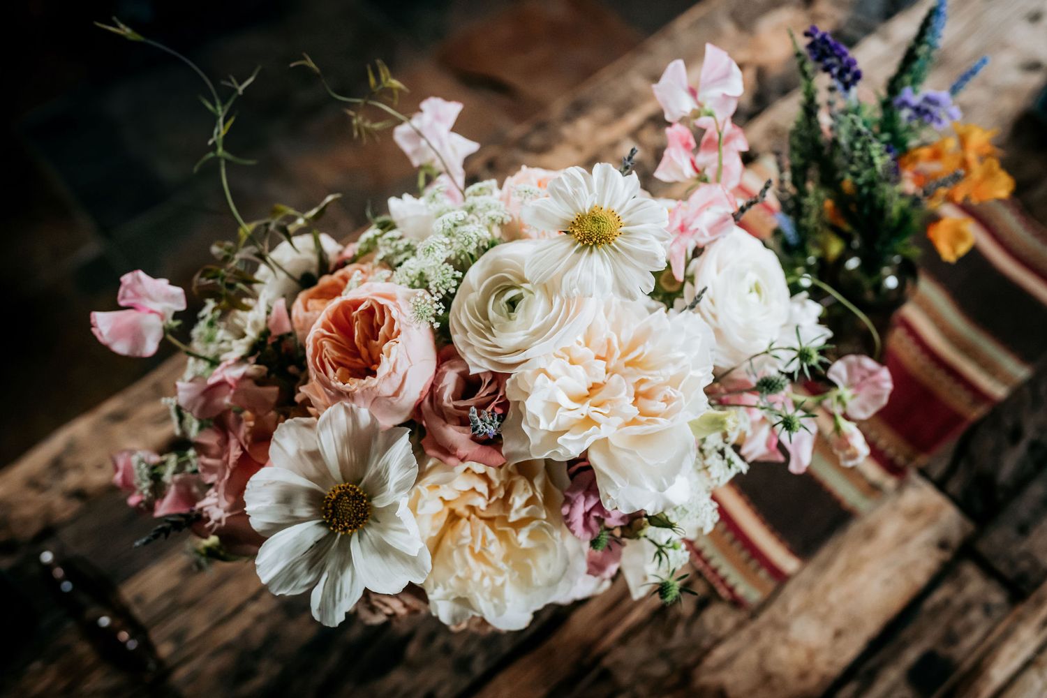 Beautiful wedding bouquet with pink and white flowers arranged on wooden surface.