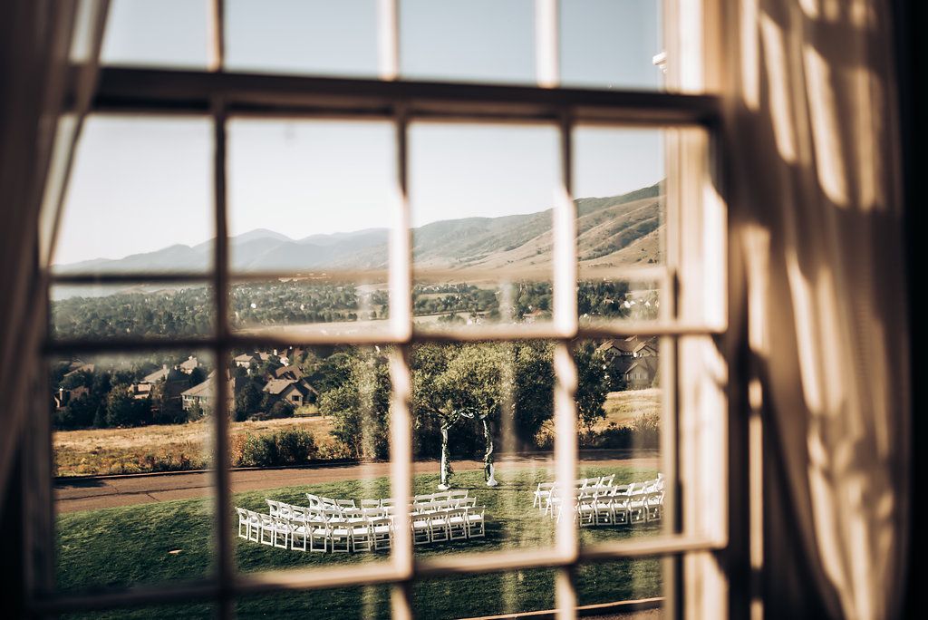 Scenic mountain landscape viewed through a classic window pane with dramatic shadows.
