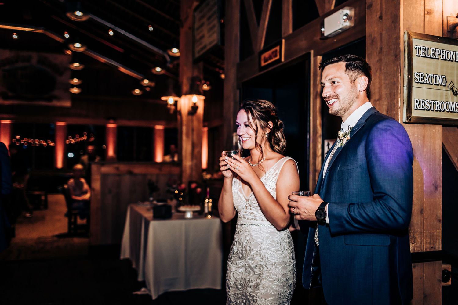 Celebration in rustic wooden venue with warm ambient lighting.