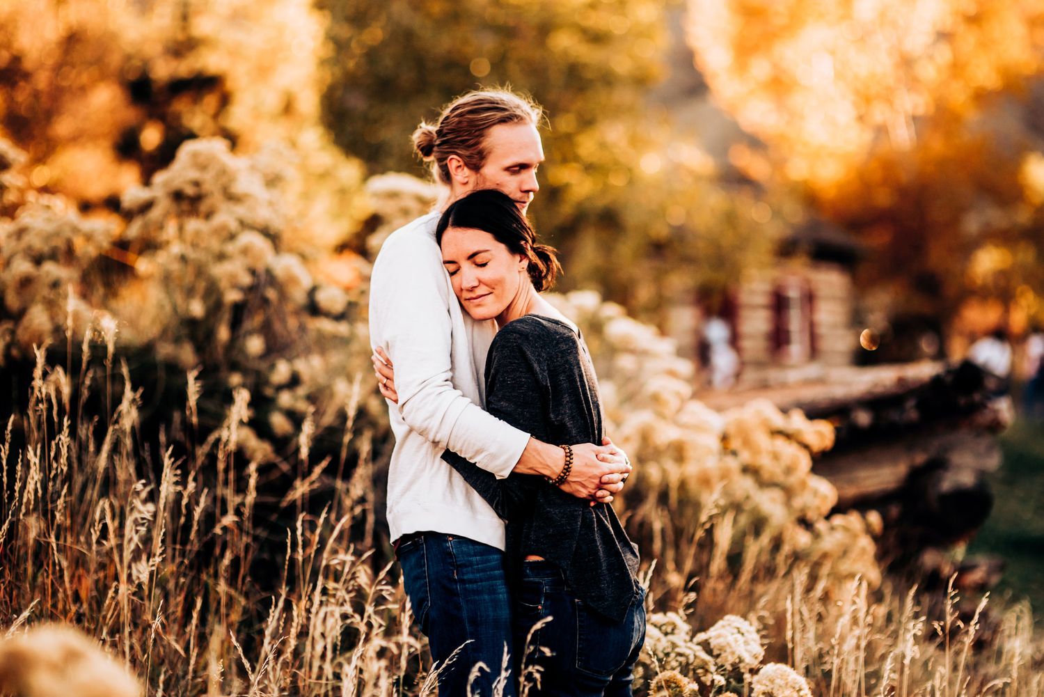 A couple dances together on a mountain trail during golden hour surrounded by fall foliage.