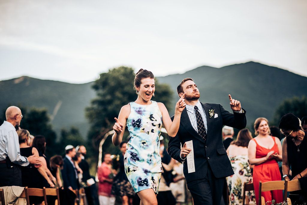 Wedding guests dancing and celebrating during an outdoor mountain reception.
