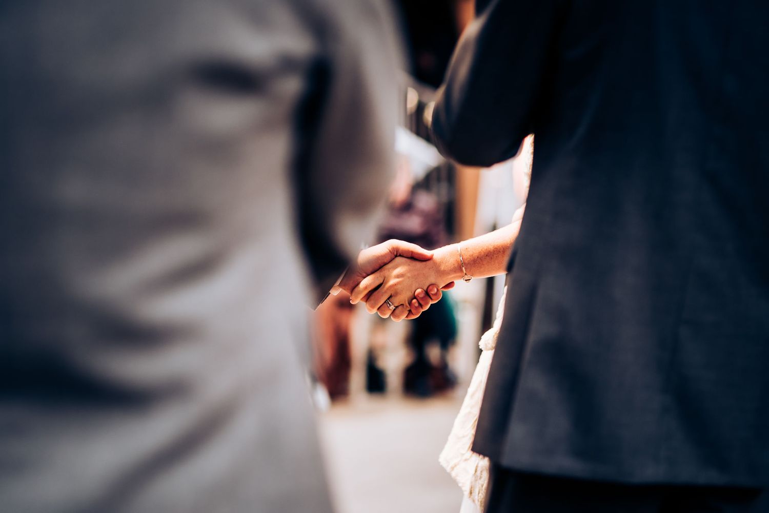 Close-up of hands during wedding ceremony exchange.