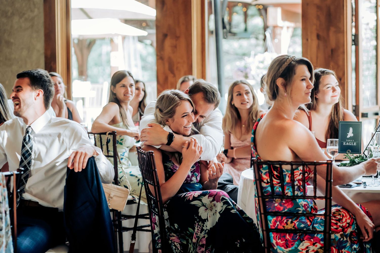 Wedding guests laugh and enjoy themselves during the reception celebration.