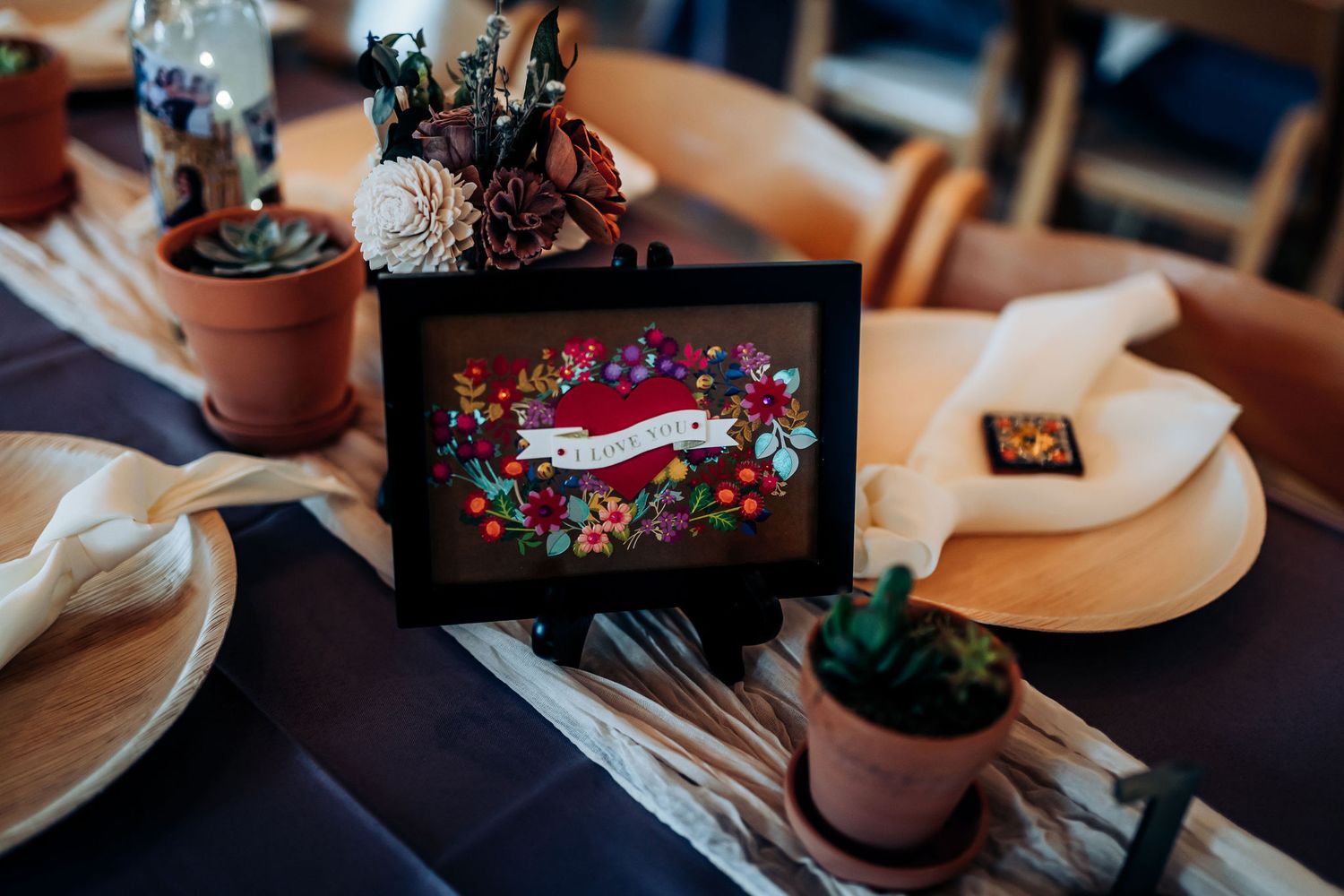 Restaurant table setting with digital display and small potted plants.