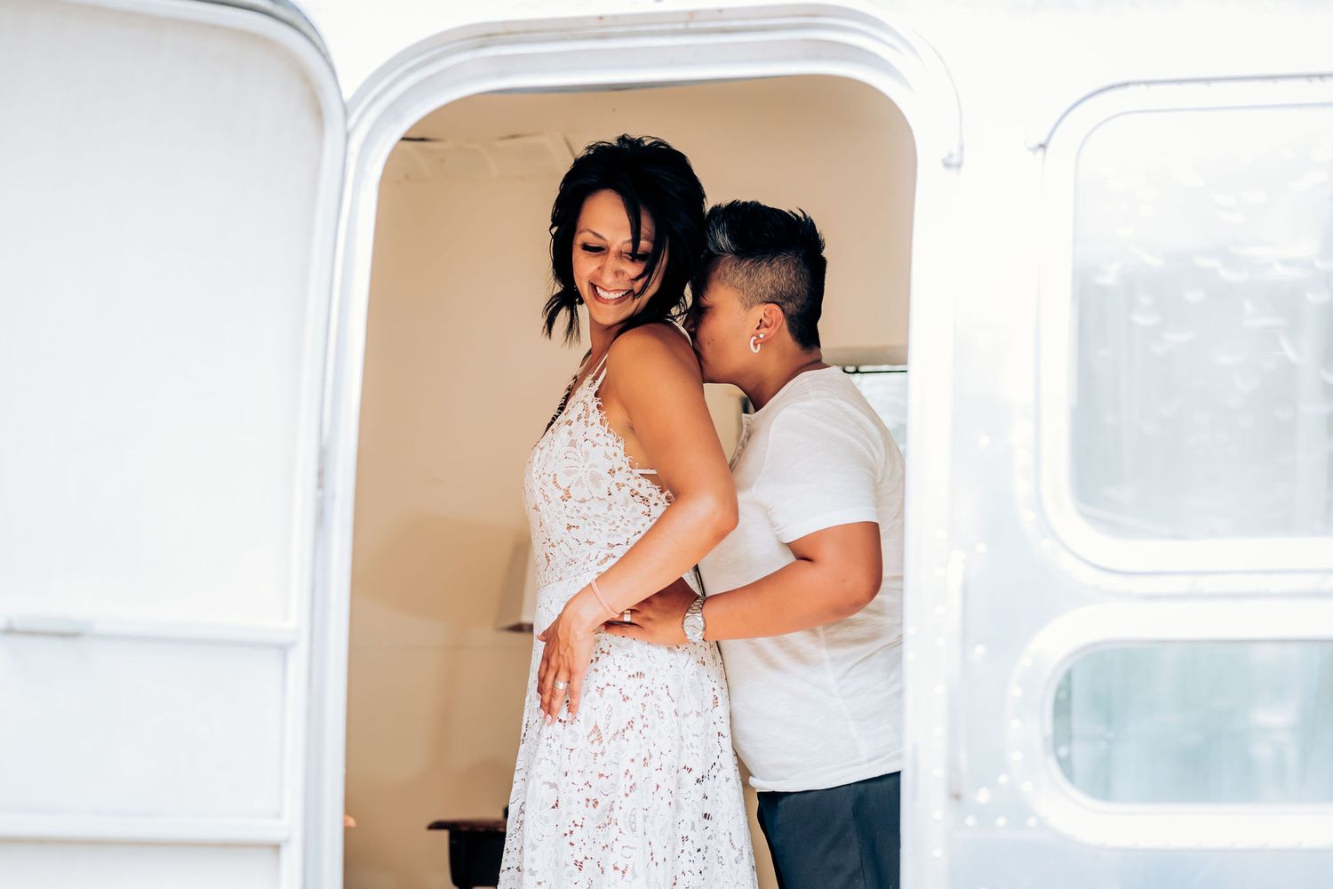 Person helping with dress adjustments during a fitting session.