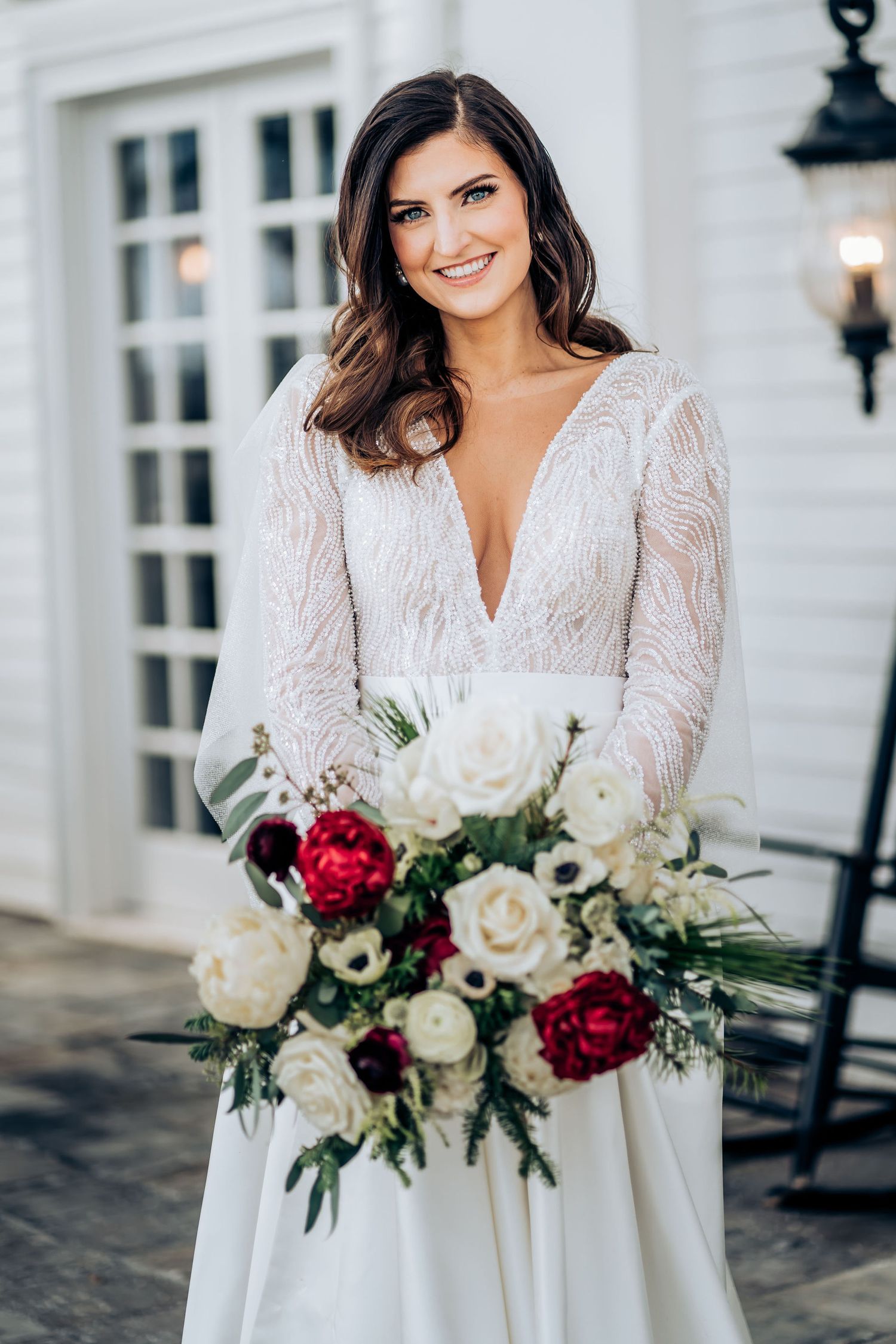 Stunning bridal portrait featuring a plunging neckline lace gown and winter bouquet.