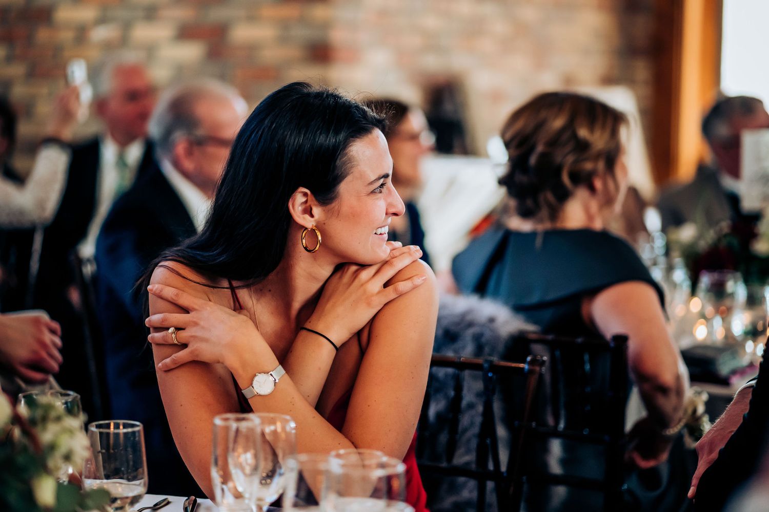 Guest enjoying an elegant wedding reception at a rustic venue with exposed brick walls.
