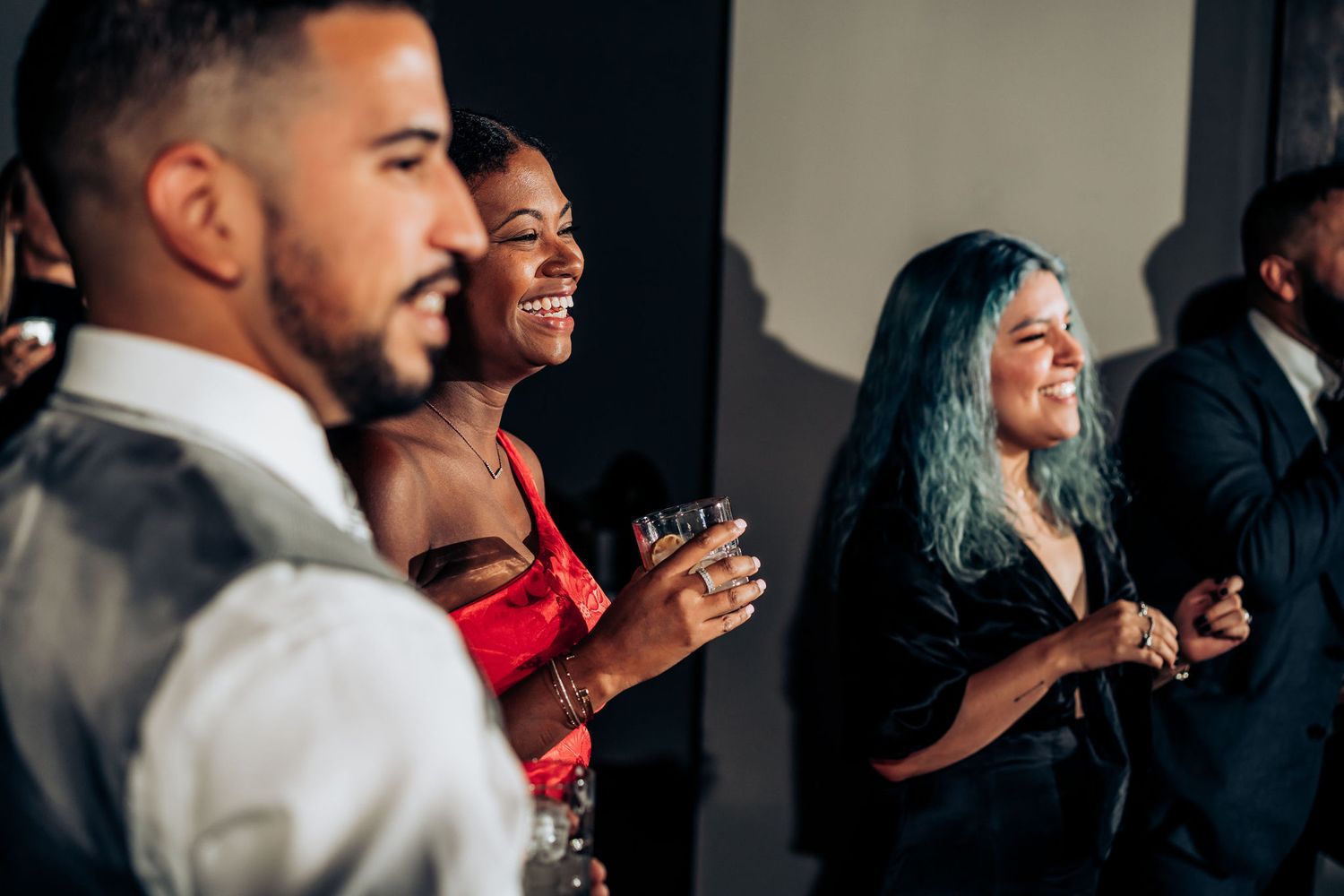 Guests laugh and dance during vibrant wedding reception celebration.