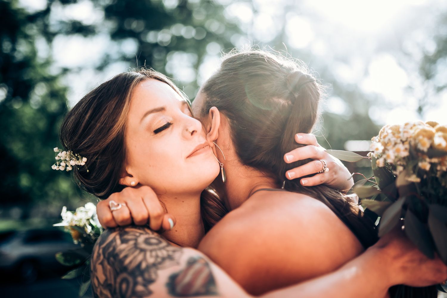 Intimate moment between newlyweds outdoors with soft natural lighting.
