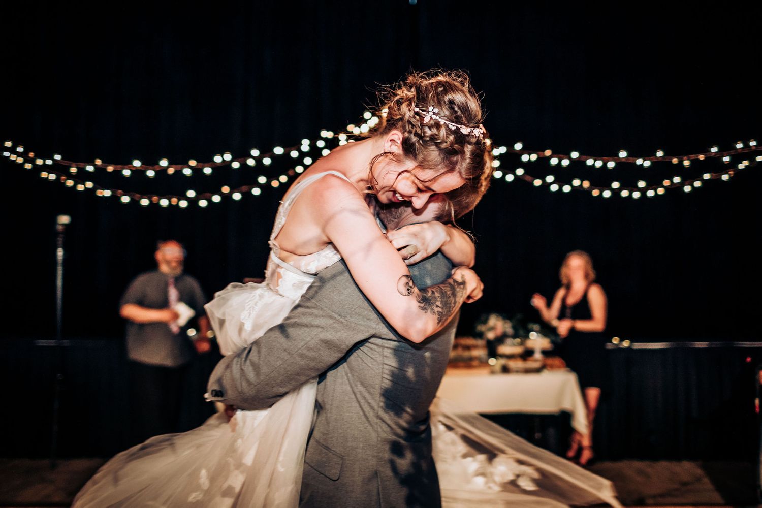 A couple performs a dramatic dance dip during their wedding reception.