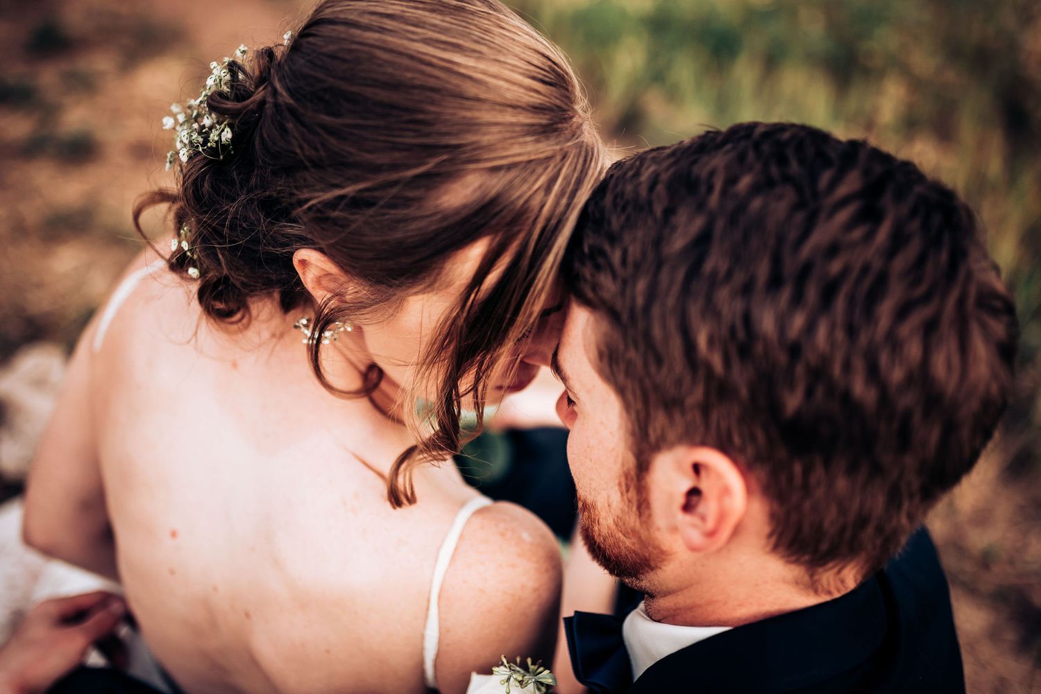 An intimate wedding moment captured in warm natural light on a mountain trail.