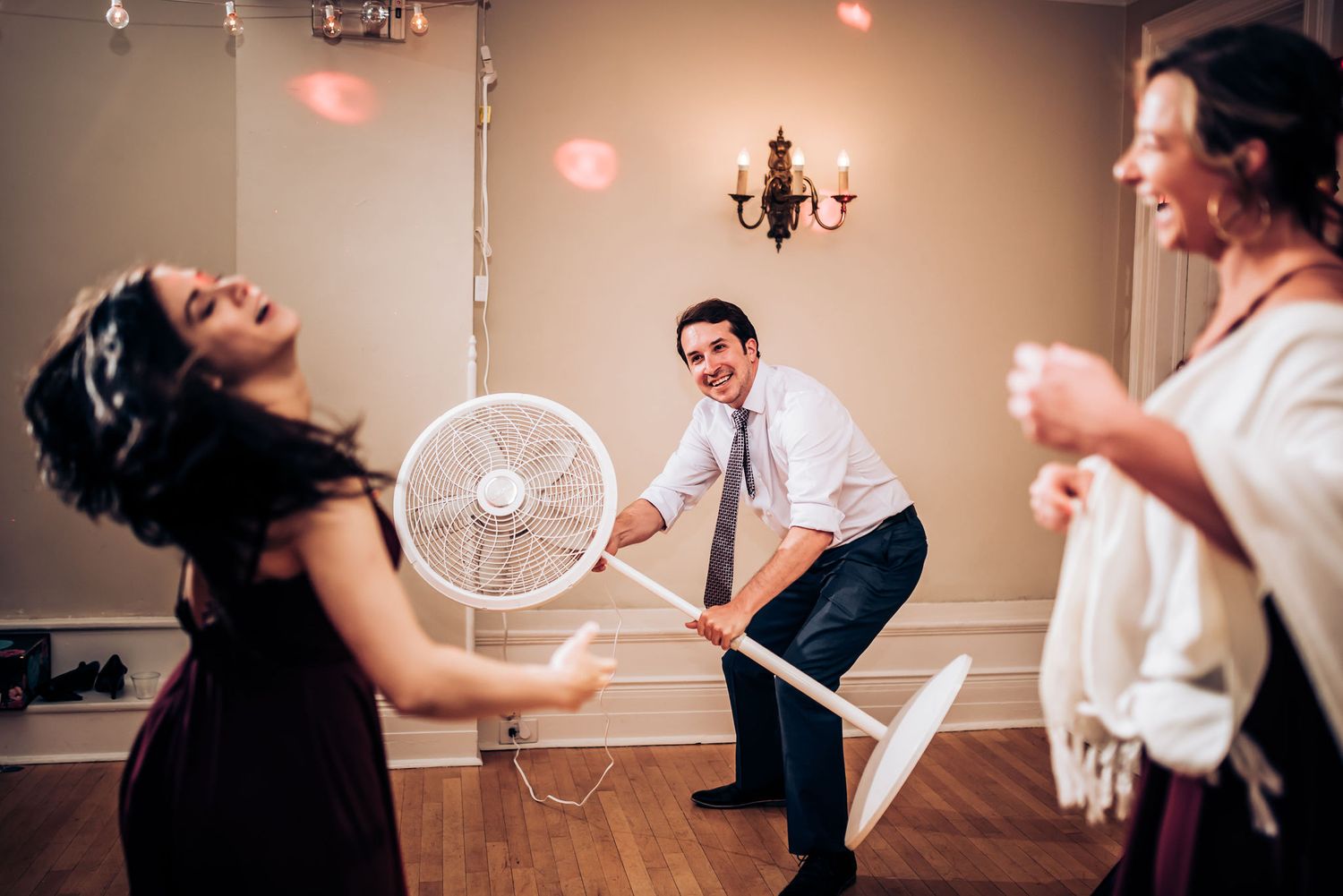 Guests having fun dancing and playing with props at a lively wedding reception.