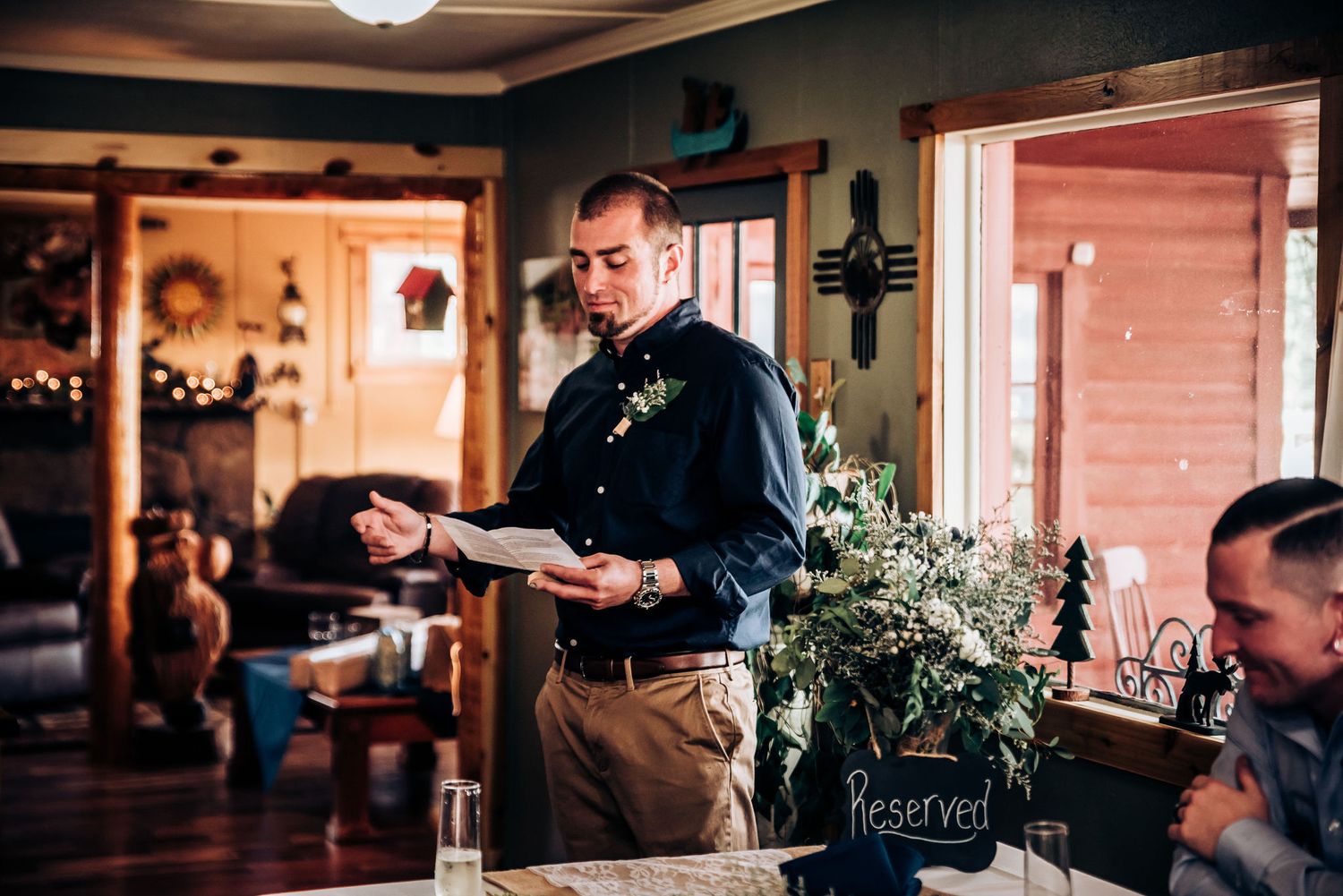 A person giving a speech in a warmly lit rustic indoor venue with holiday decorations.