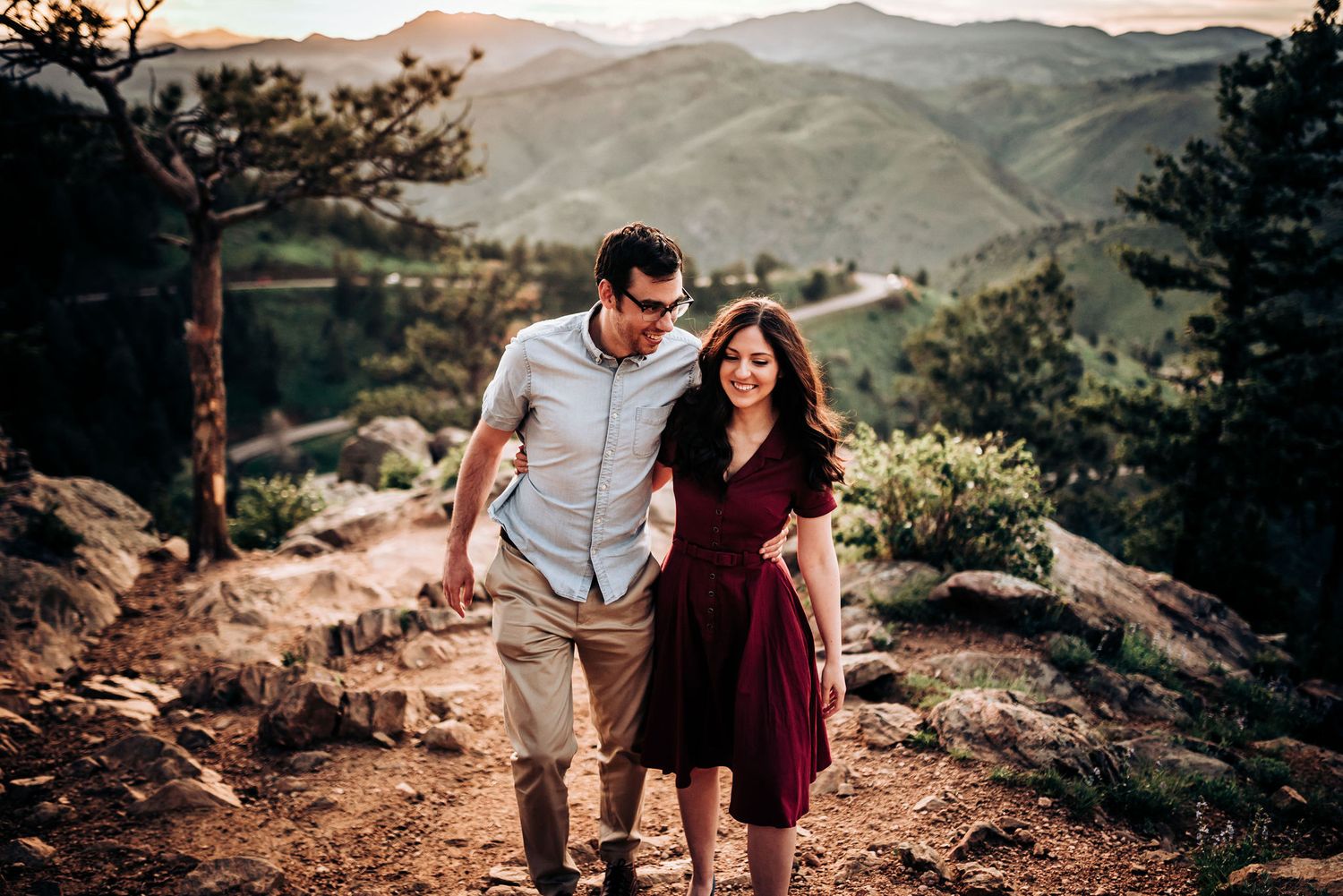 Happy couple exploring mountain trails with scenic valley views.