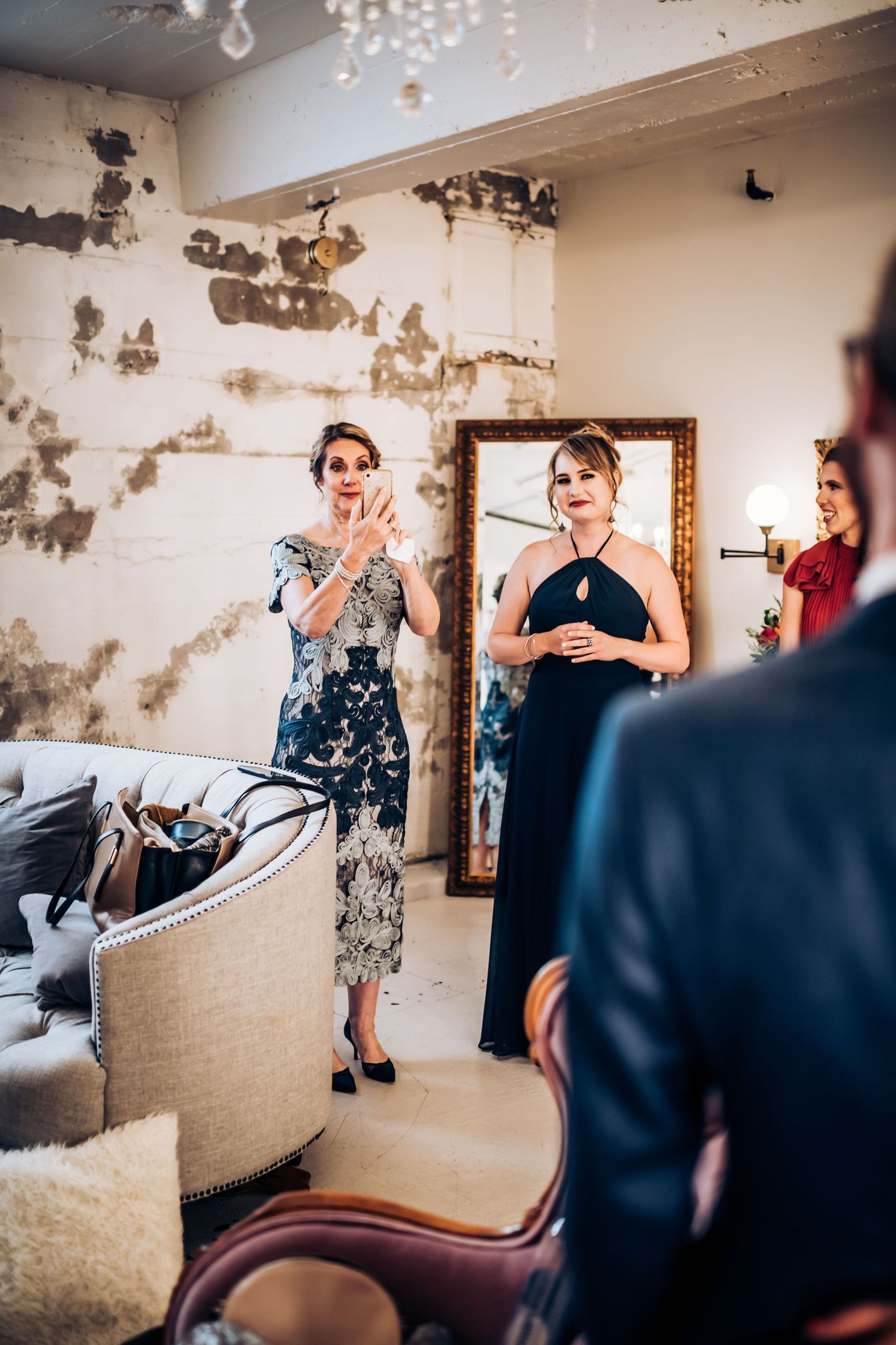 Wedding guests react emotionally during ceremony in vintage-style room with distressed walls.
