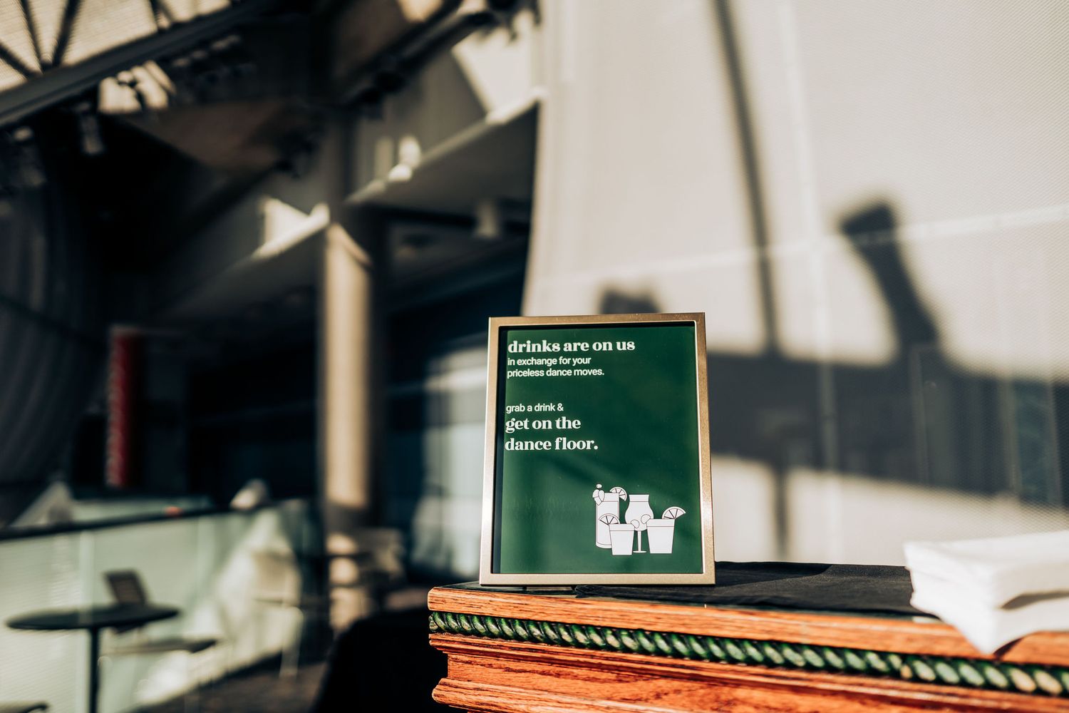 A dark green hardcover book displayed on an orange surface in an industrial-style setting.