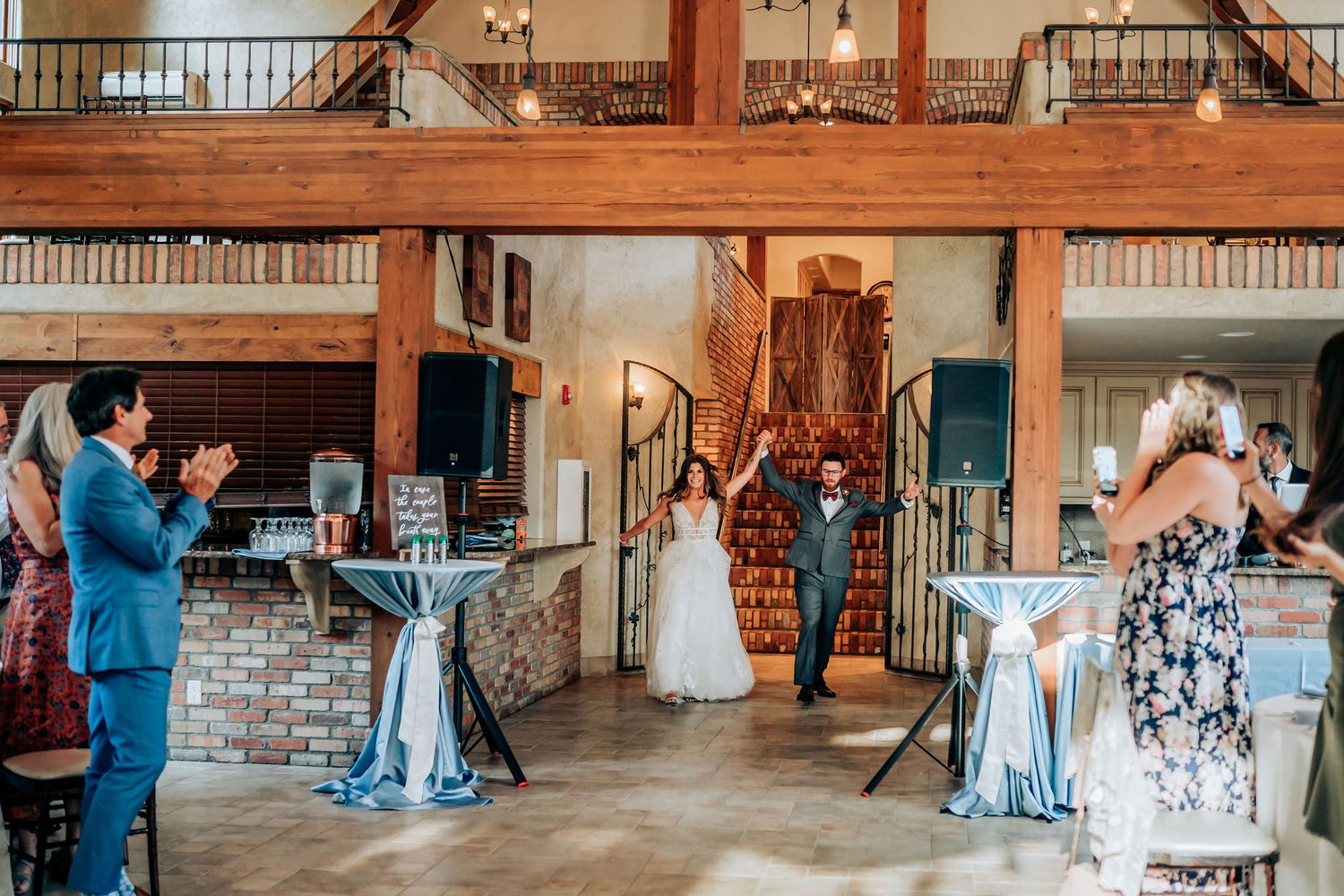 Wedding celebration moment captured in rustic venue with wooden details and blue decor.