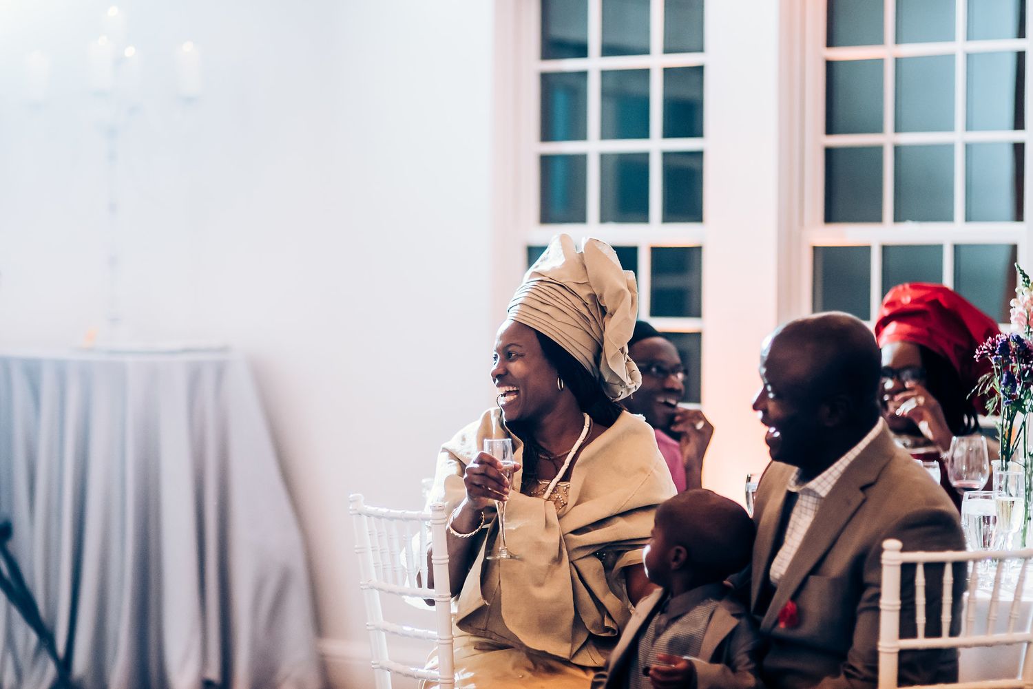 Wedding guests in traditional African attire share a joyful moment during the reception celebration.