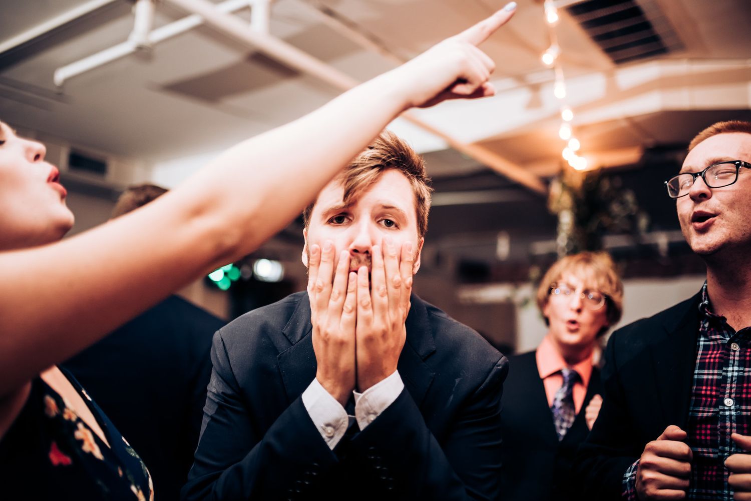 Party guest shows emotional reaction during celebration under indoor lighting.
