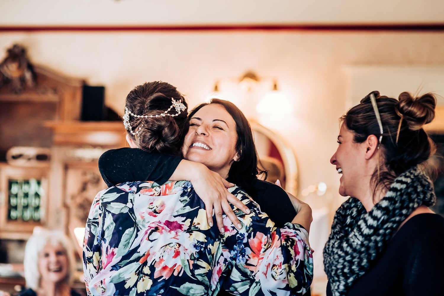 People in formal attire share a touching group embrace during a celebratory moment.