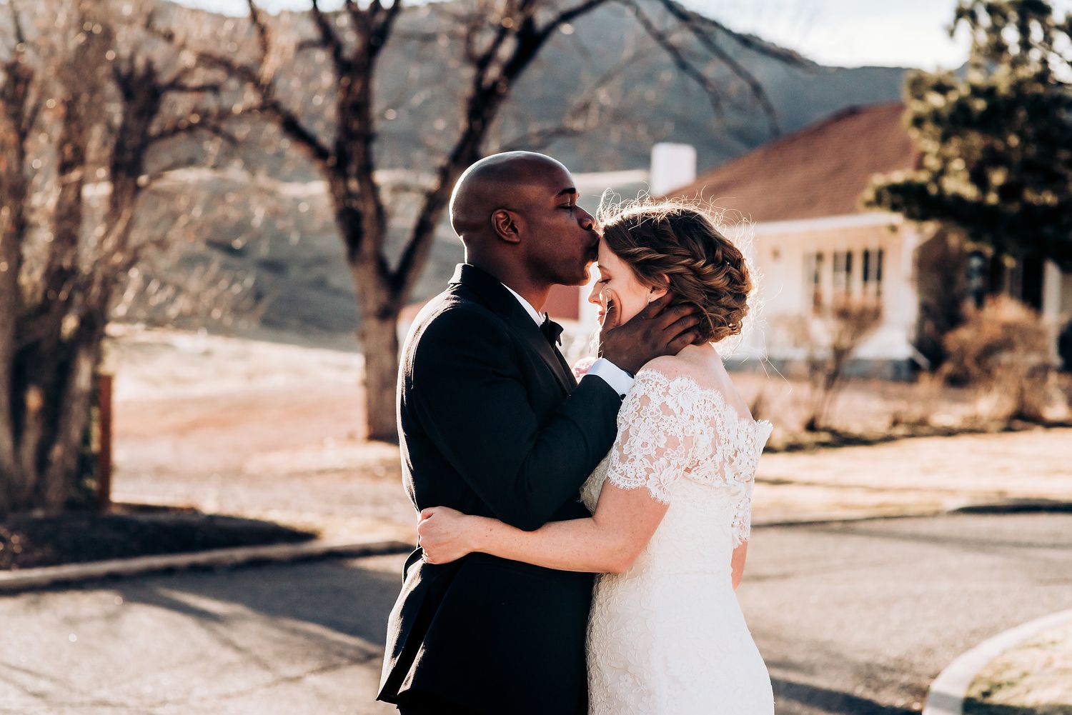 Intimate wedding moment captured with mountain backdrop at sunset.