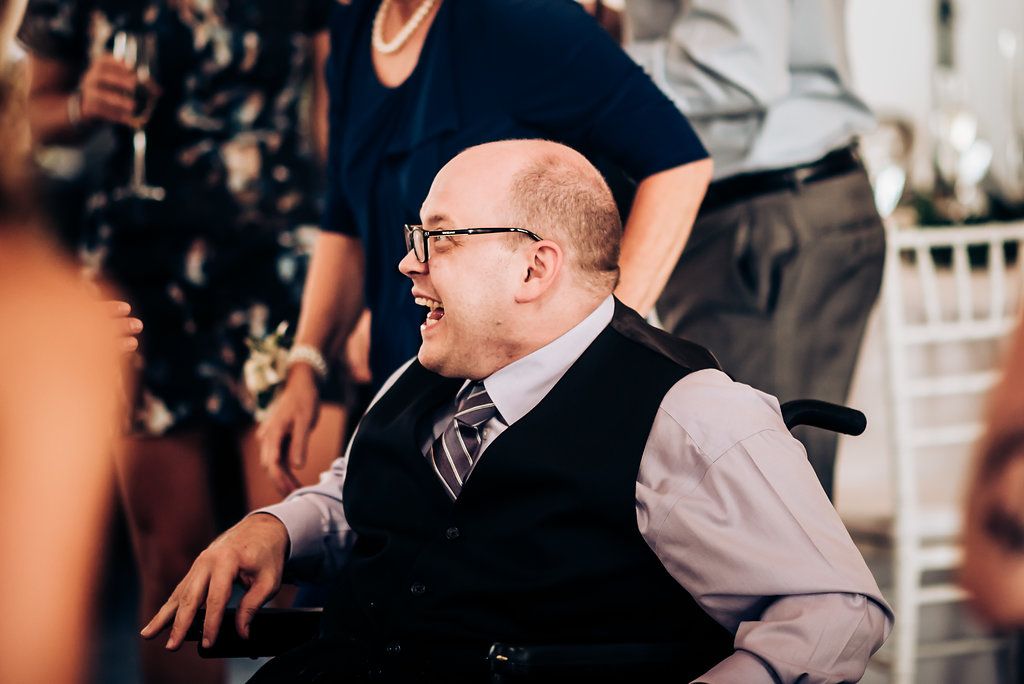 Guest in wheelchair enjoying celebration at indoor event venue.