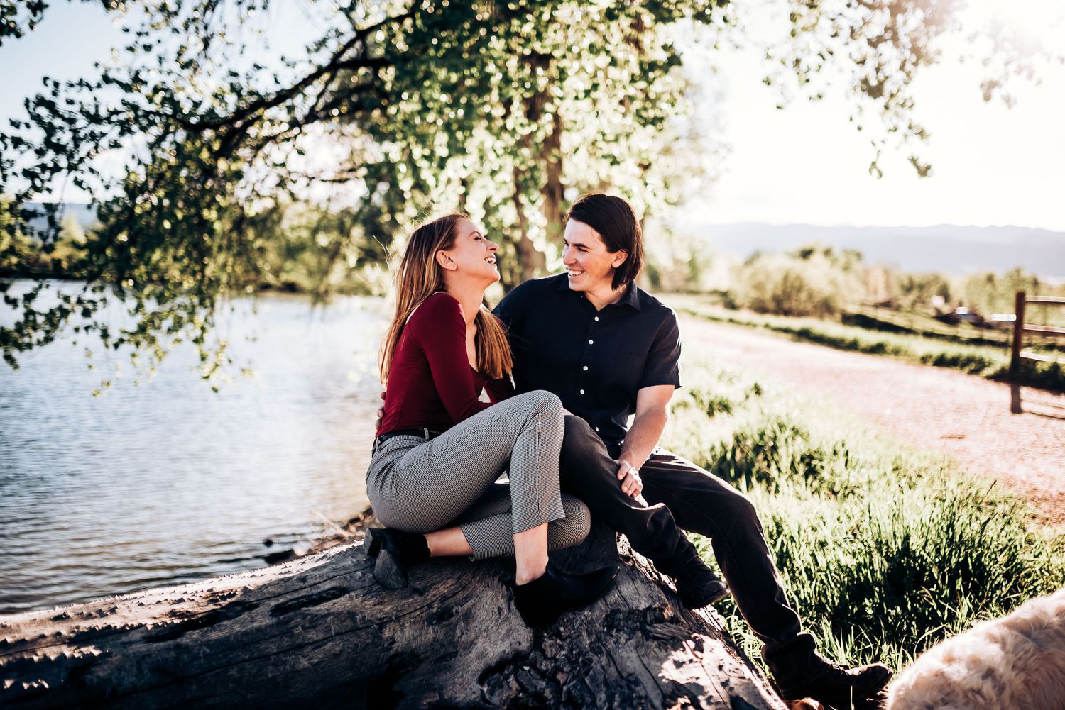 Couple enjoys romantic moment on rock by scenic lake.