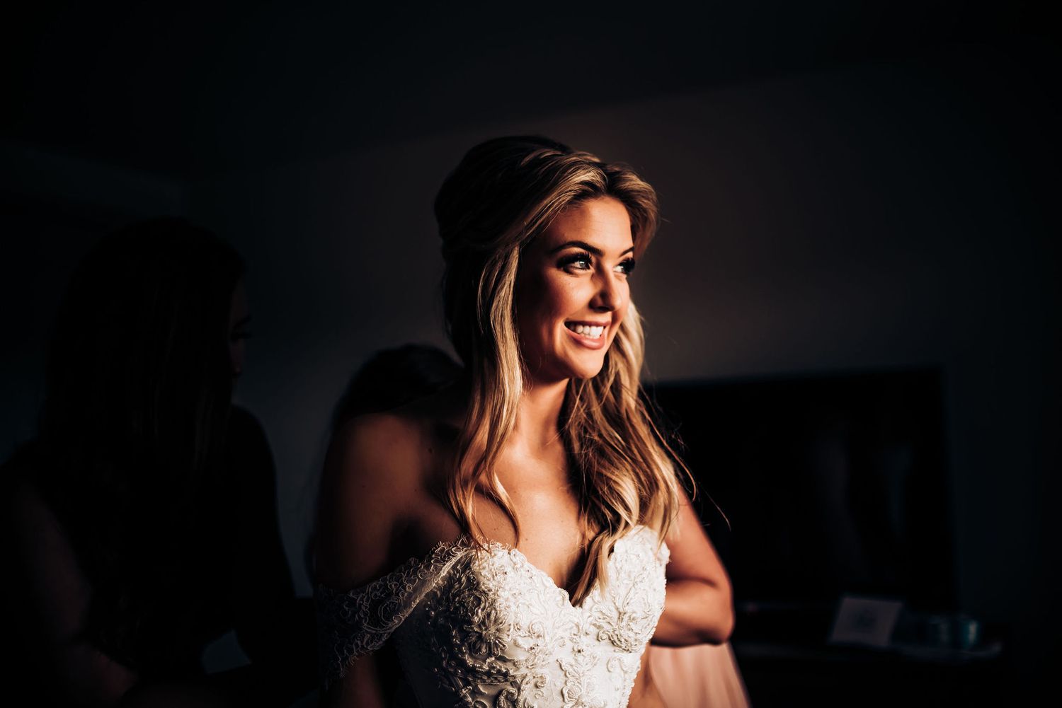 Artistic portrait of a wedding dress with dramatic side lighting creating shadows and highlights.