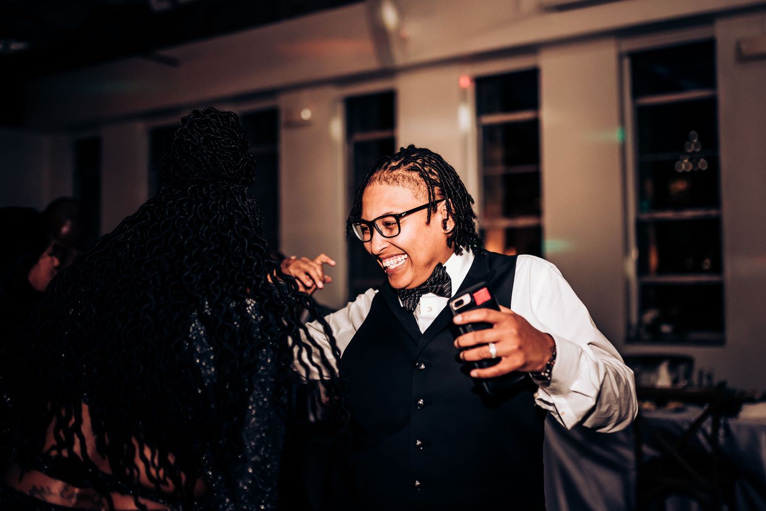 A server in formal attire interacts with guests during an elegant reception.