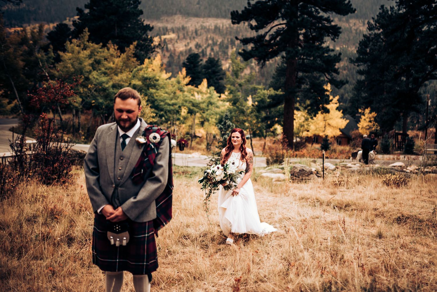 Scottish wedding in mountains with groom wearing traditional kilt against autumn landscape.