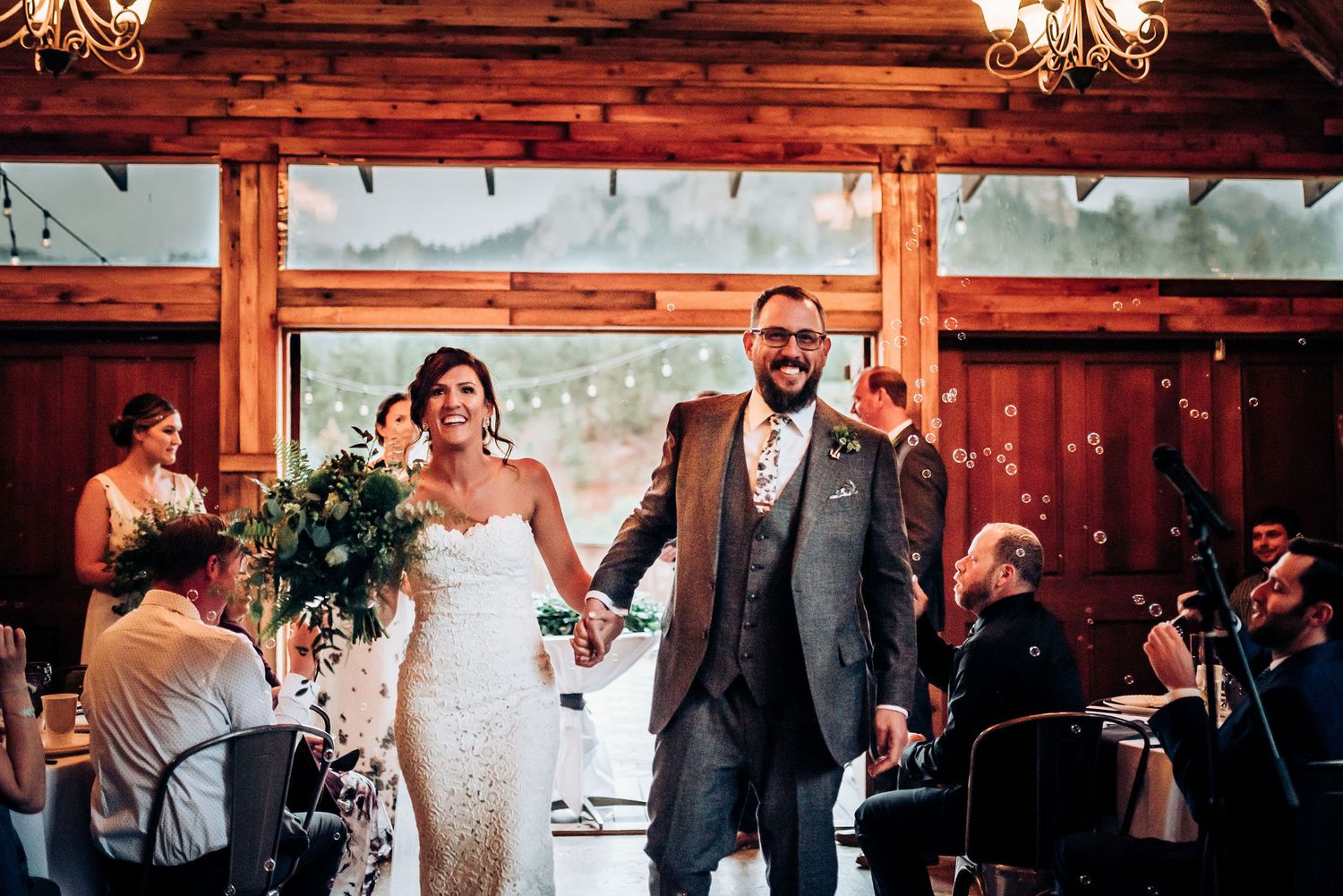 Newlyweds celebrate while exiting their ceremony in a rustic barn venue.