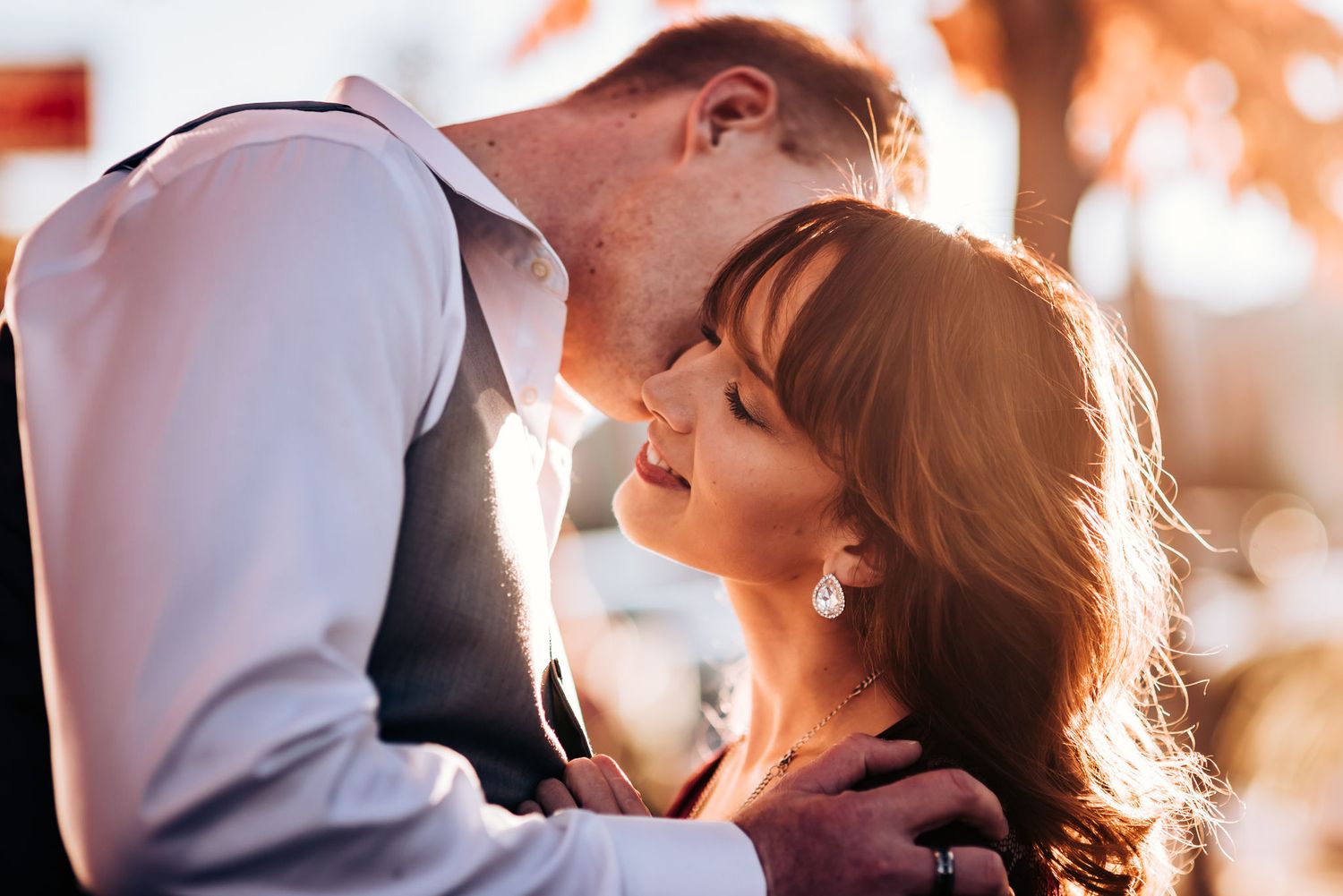 Tender romantic moment between couple in warm sunset lighting.