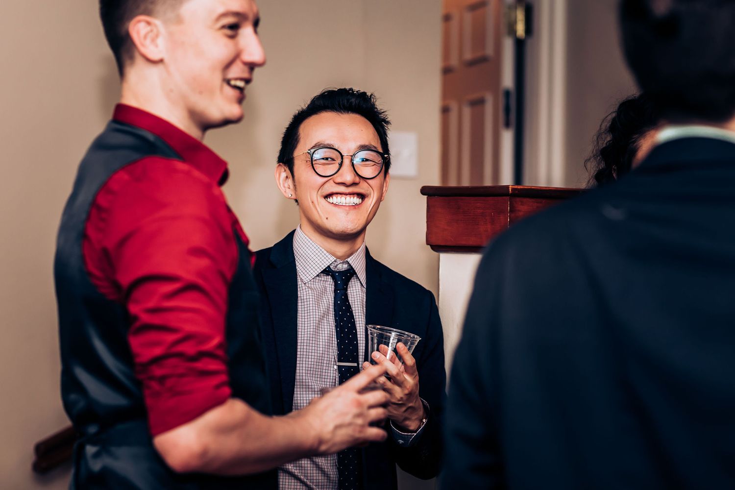 Wedding guests sharing laughs and drinks during the reception celebration.