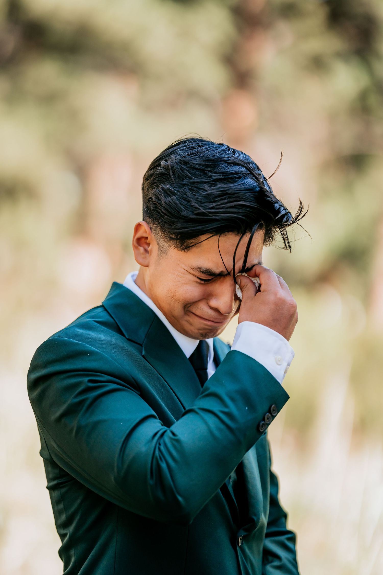 An emotional moment captured during a wedding ceremony in an outdoor setting.